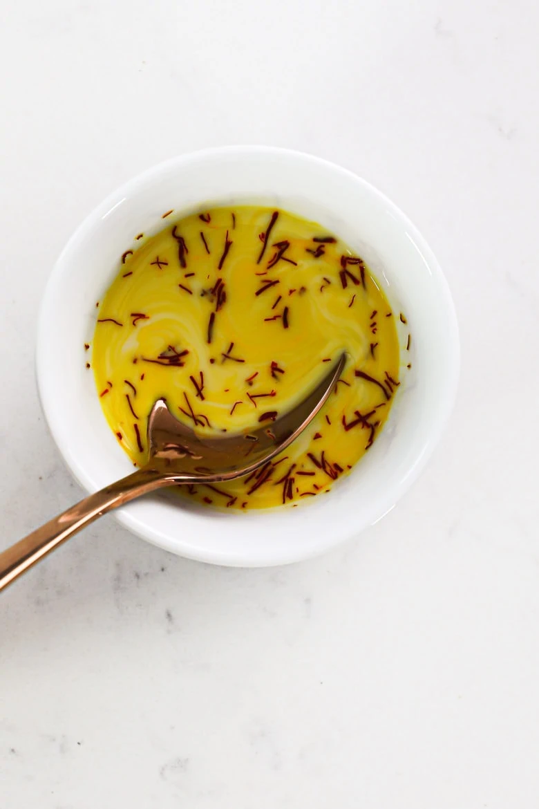 a ramekin with saffron and milk to create a yellow milk.