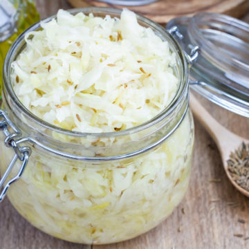 Homemade sauerkraut with cumin in a glass jar, closeup, square format