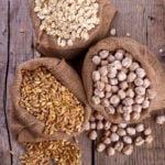 Cereals for a healthy diet, wheat, oatmeal and chickpeas in sacks on rustic wooden background