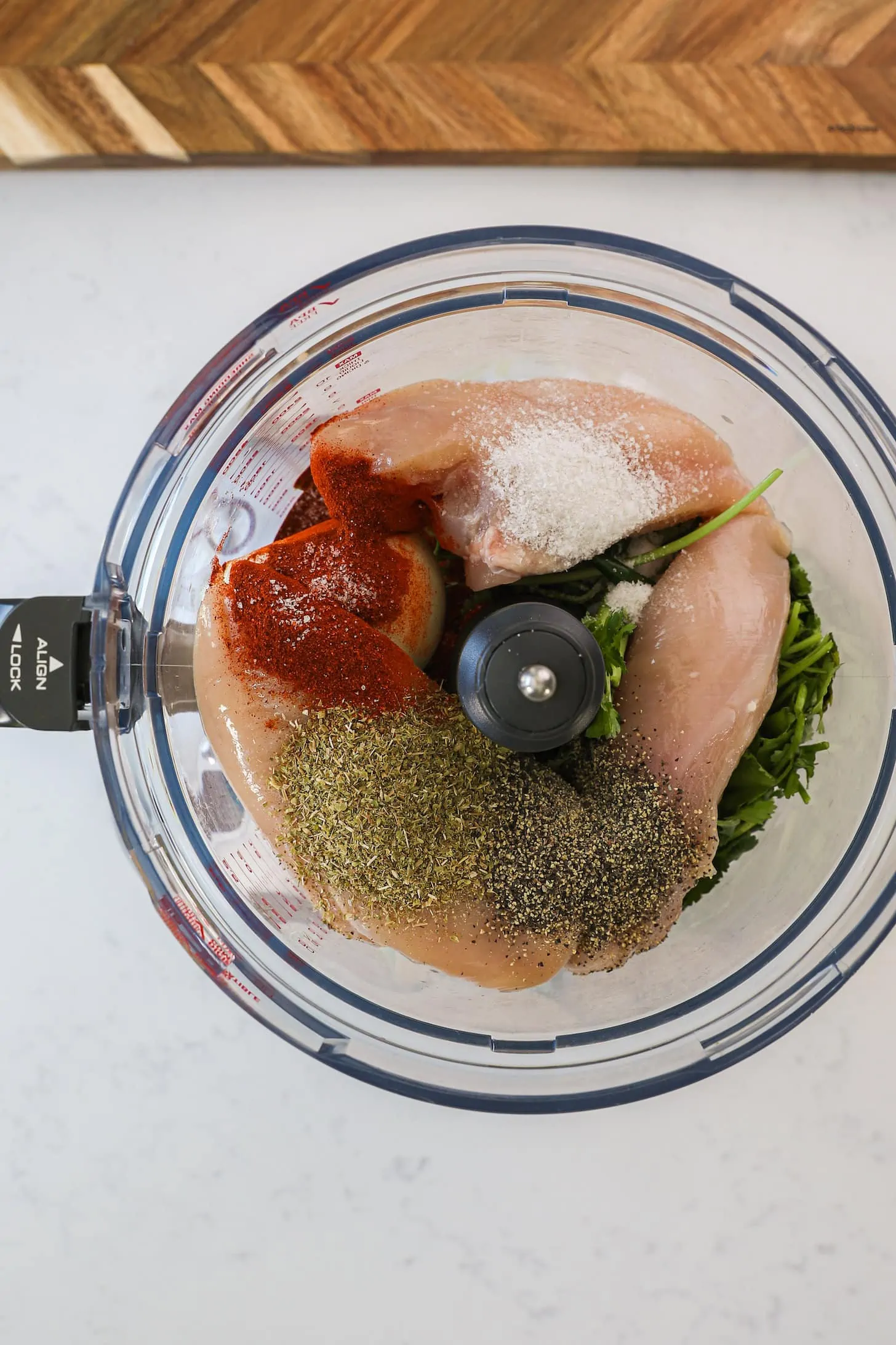 a food processor filled with chicken breast and spices.