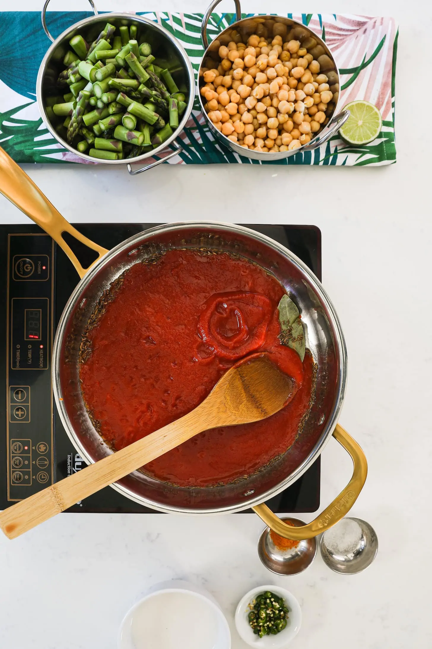 a pan of tomato sauce with a wooden spoon in it.