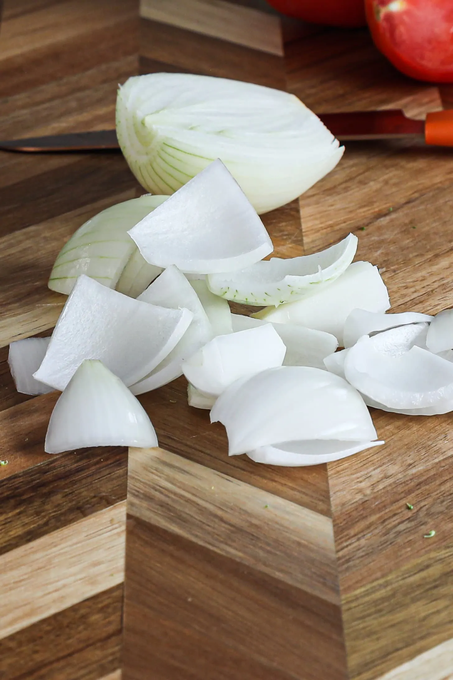 slices of white onion on a wooden board.