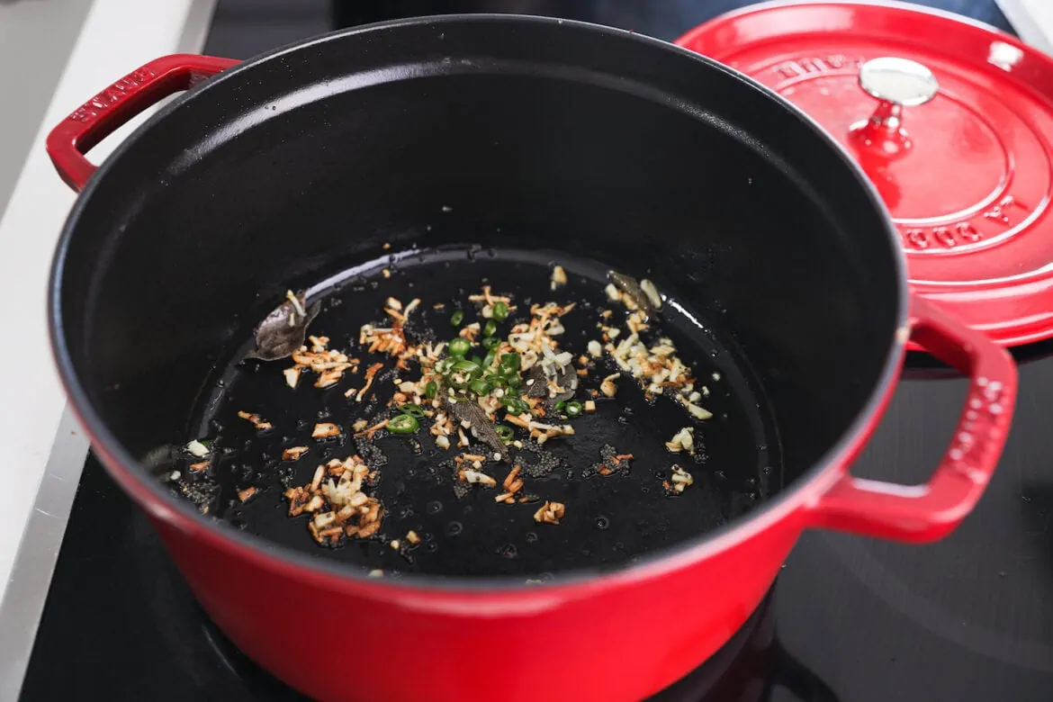 A red pot with chopped garlic and chillies.