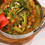 side view of cooked mixed vegetables in a yellow-coloured sauce.