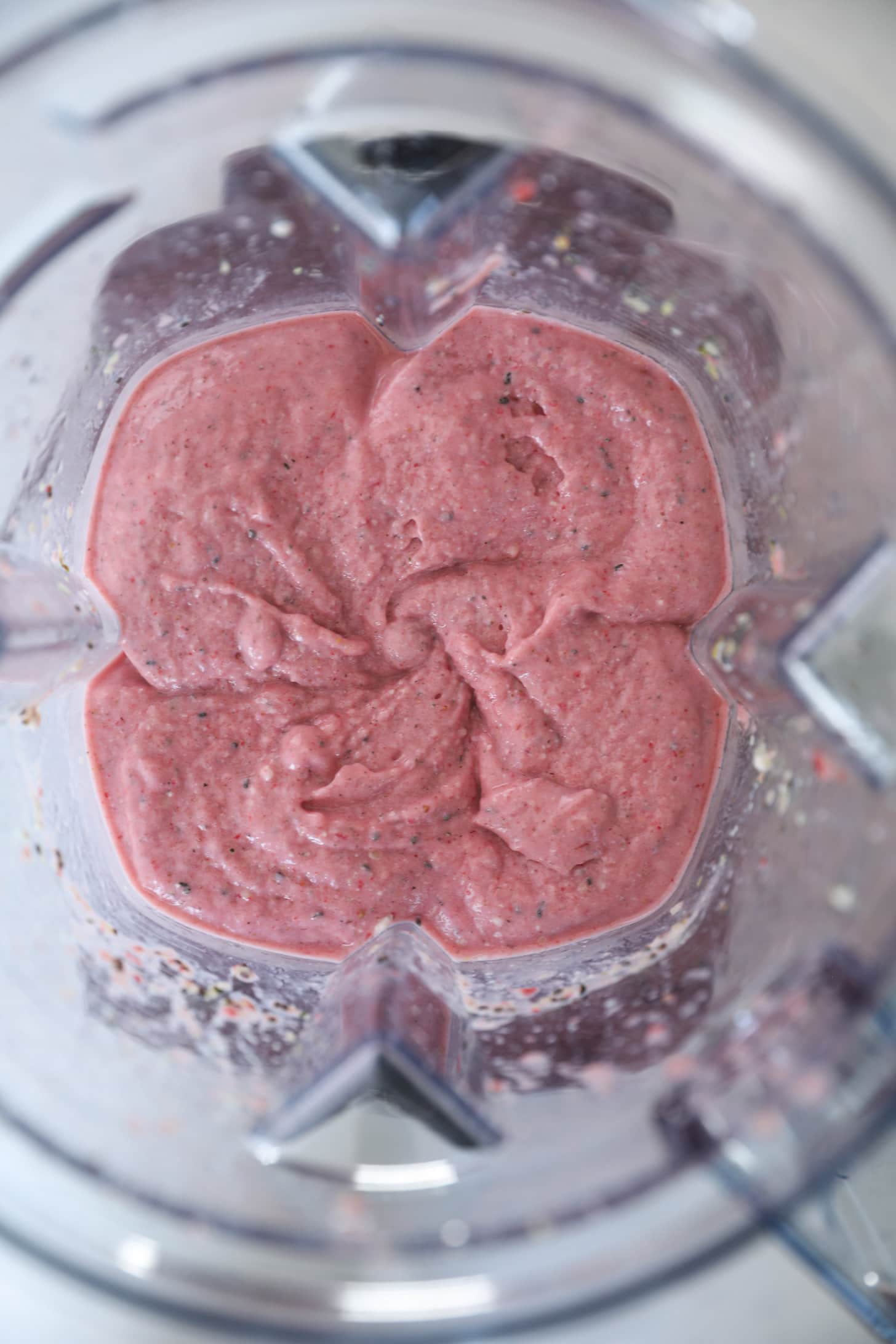 Overhead image of a pink smoothie in a blender.