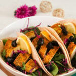 A bowl of fish tacos filled chopped prunes and vegetables.