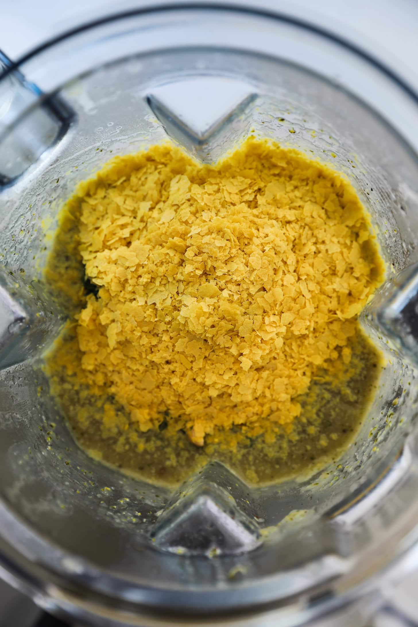 Birdseye view of a blender with yellow flakes.