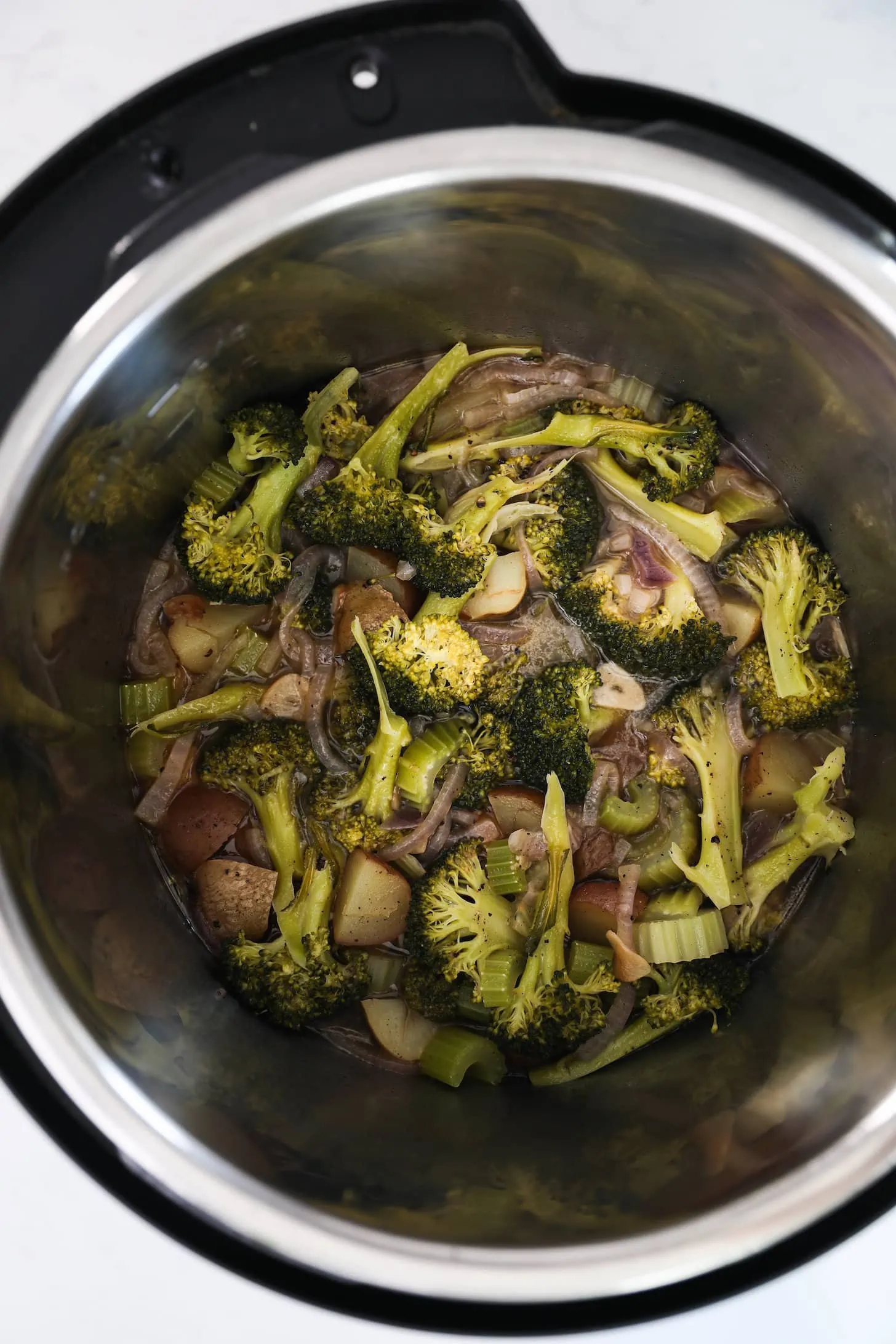 Birdseye view of Instant pot with cooked broccoli and vegetables.