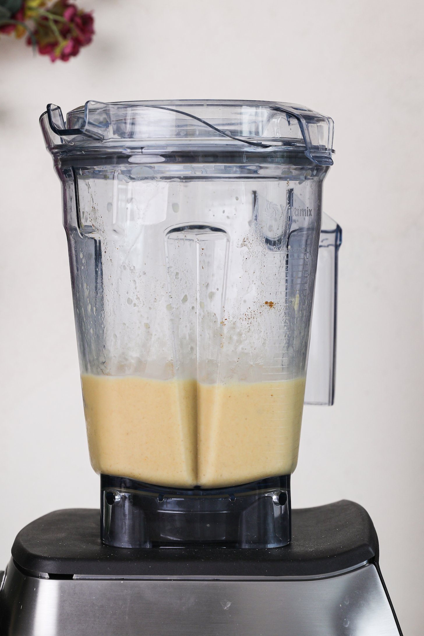 Perspective image of a blender with a yellow mixture in it.