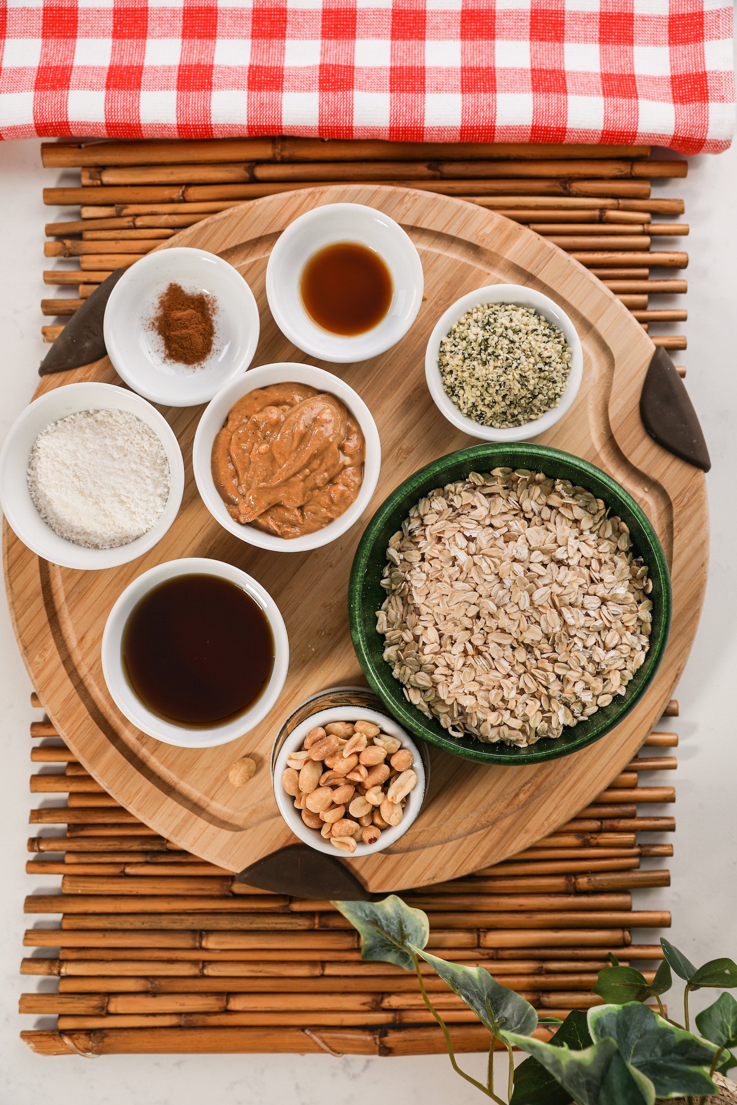 An array of food ingredients like oats, peanut butter, seeds and nuts on a wooden board.