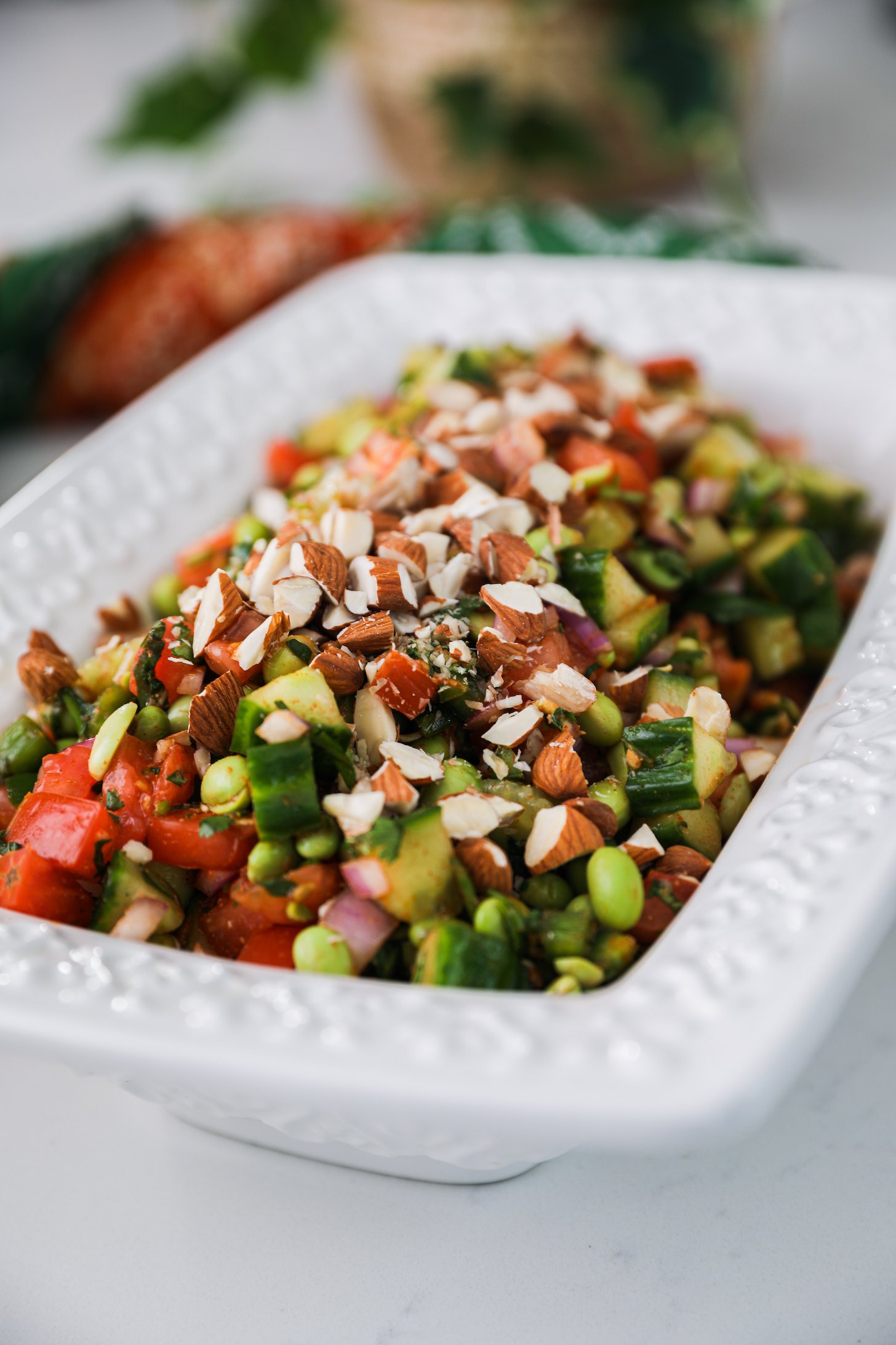 Perspective iamge of a bowl of chopped vegetables, beans and chopped almonds.