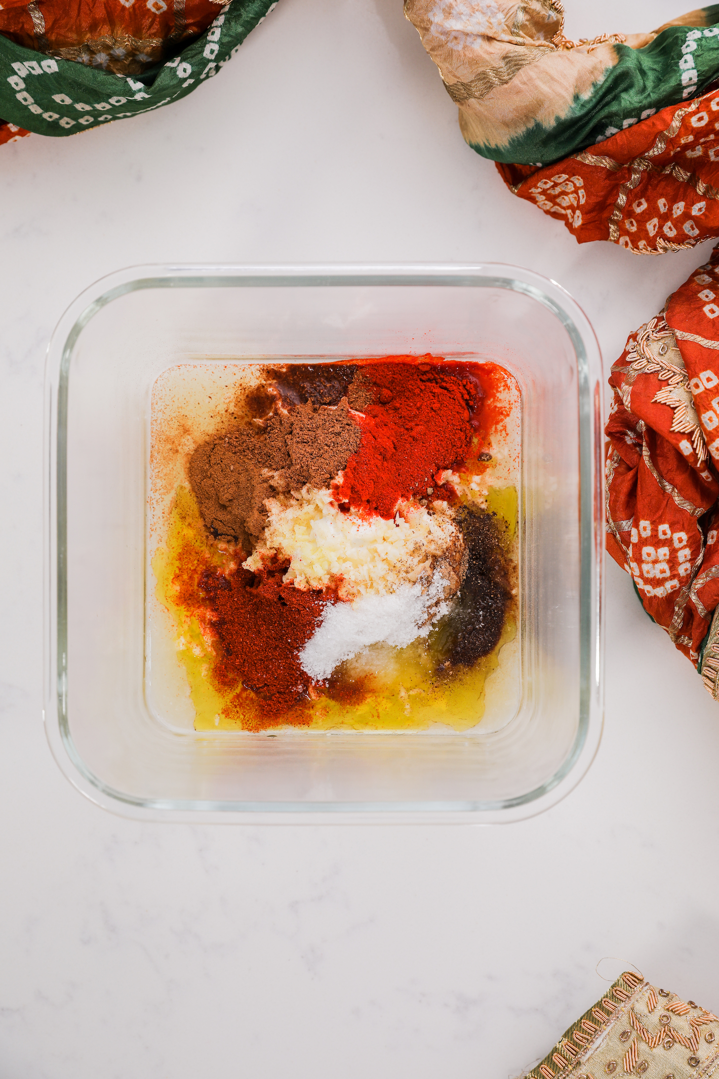 A bowl of colourful spices and oil.