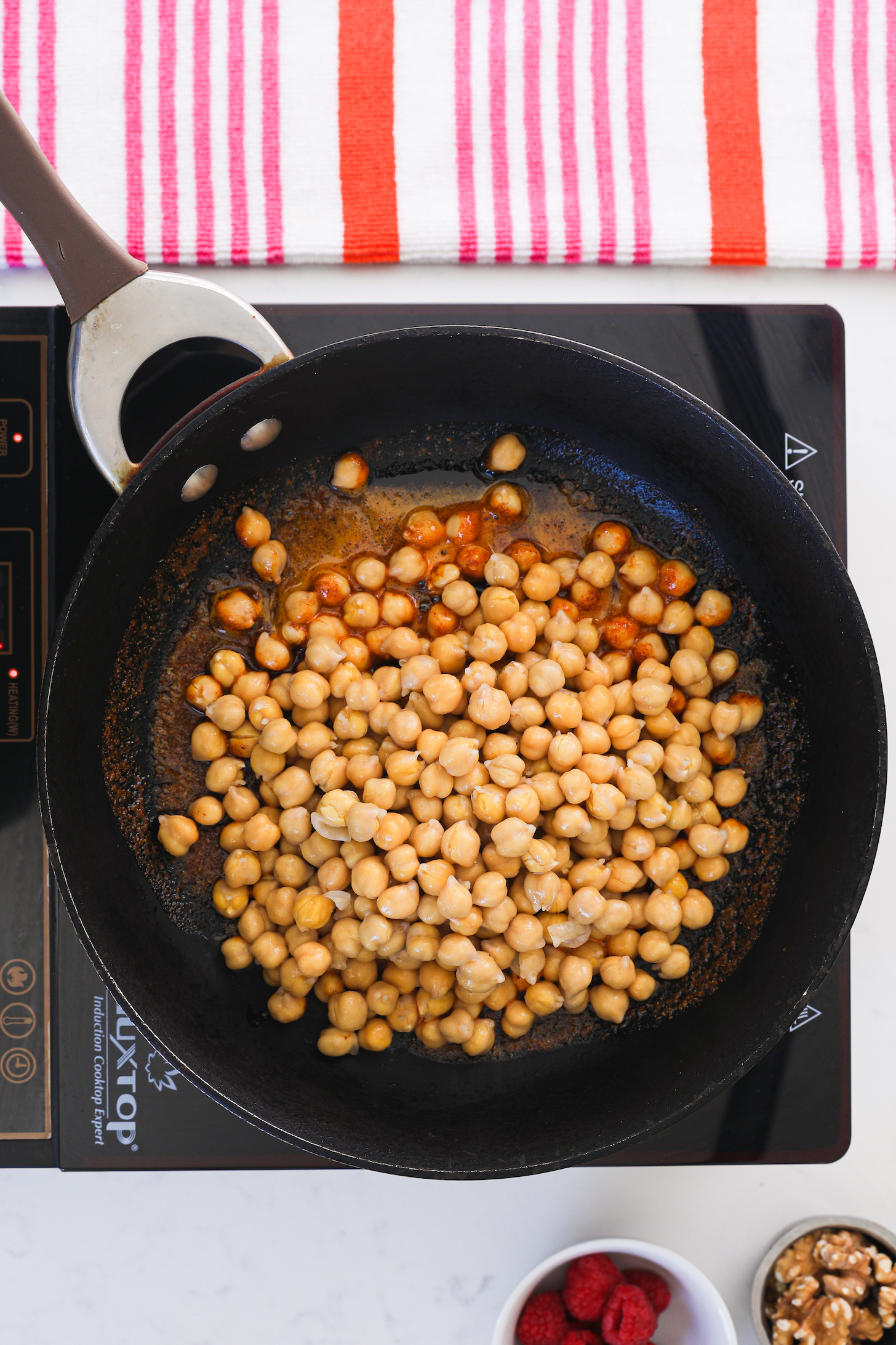 A pan of chickpeas on a cooktop.