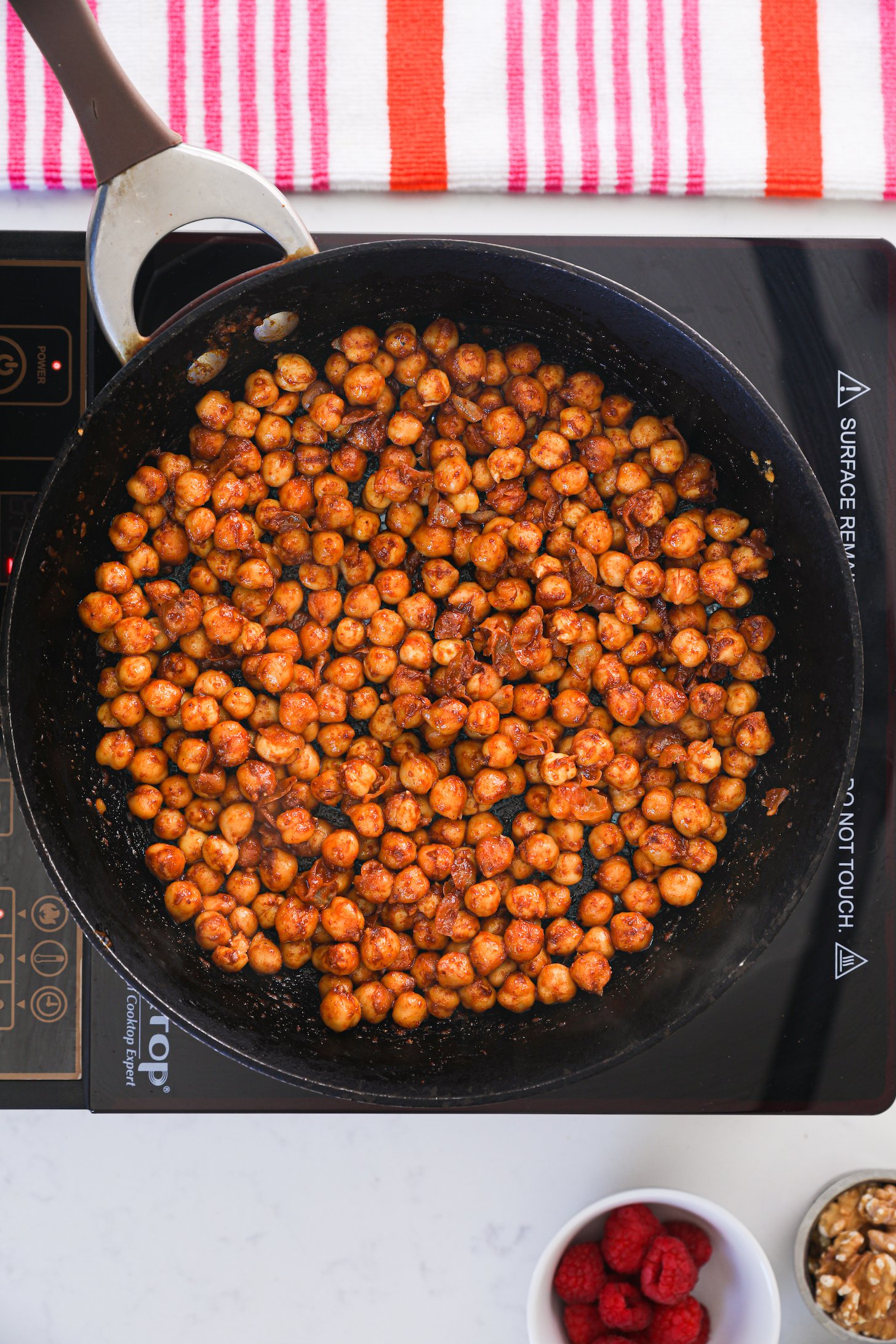 A pan of spice-coated chickpeas on a stovetop.