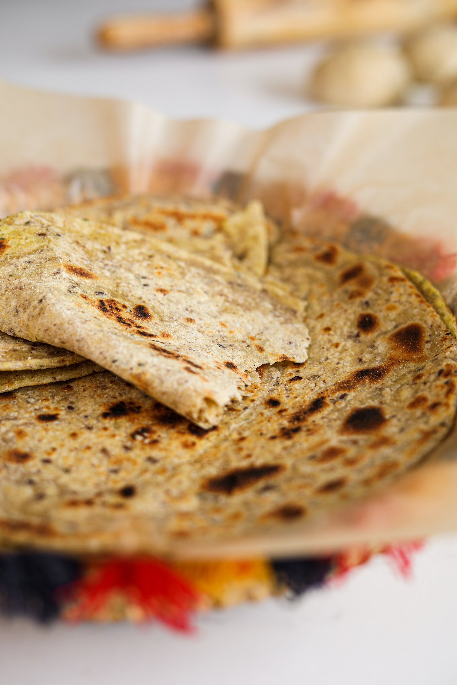 Close up of Indian flatbread (paratha) with one ripped in half and folded.