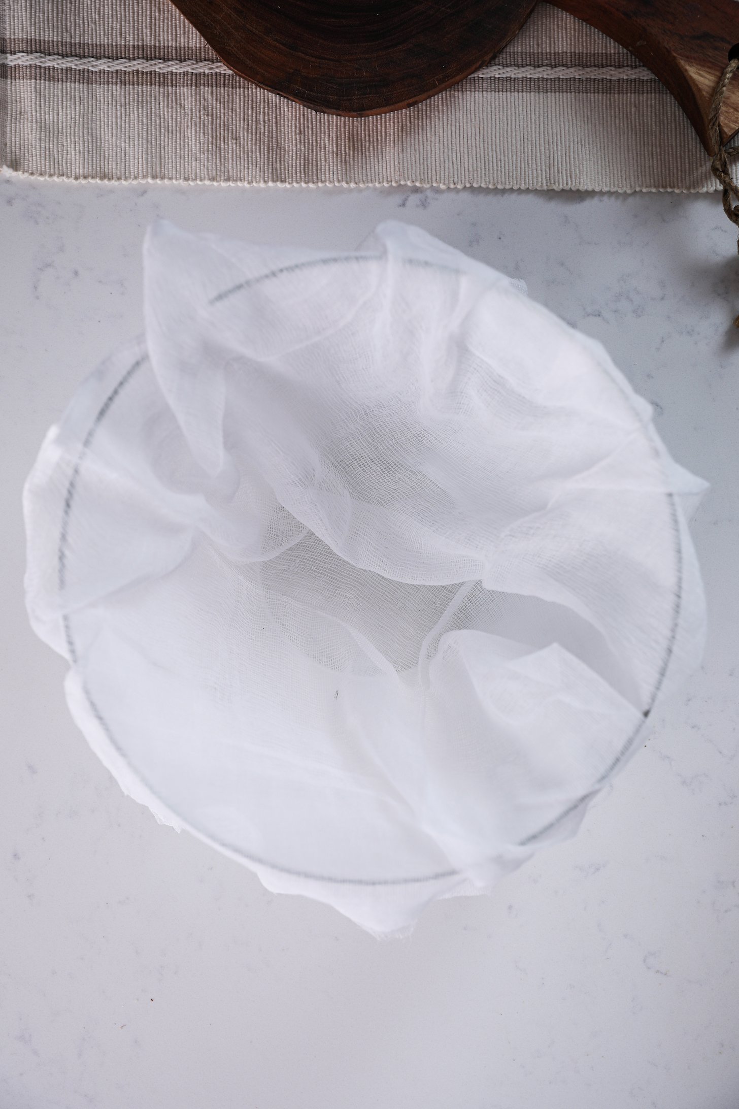 Overhead shot of a bowl lined with cheesecloth.