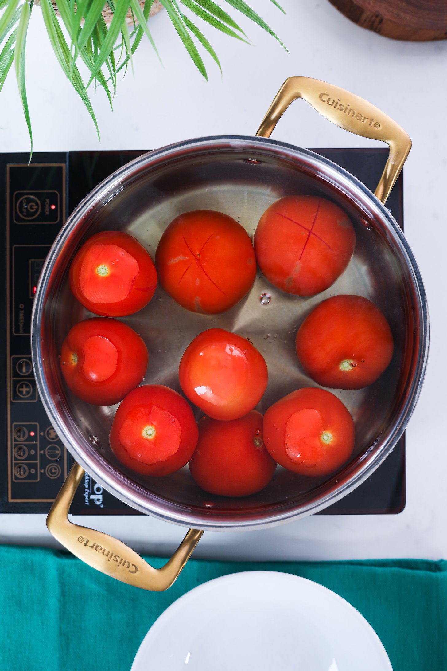Tomatoes submerged in a pot of water.