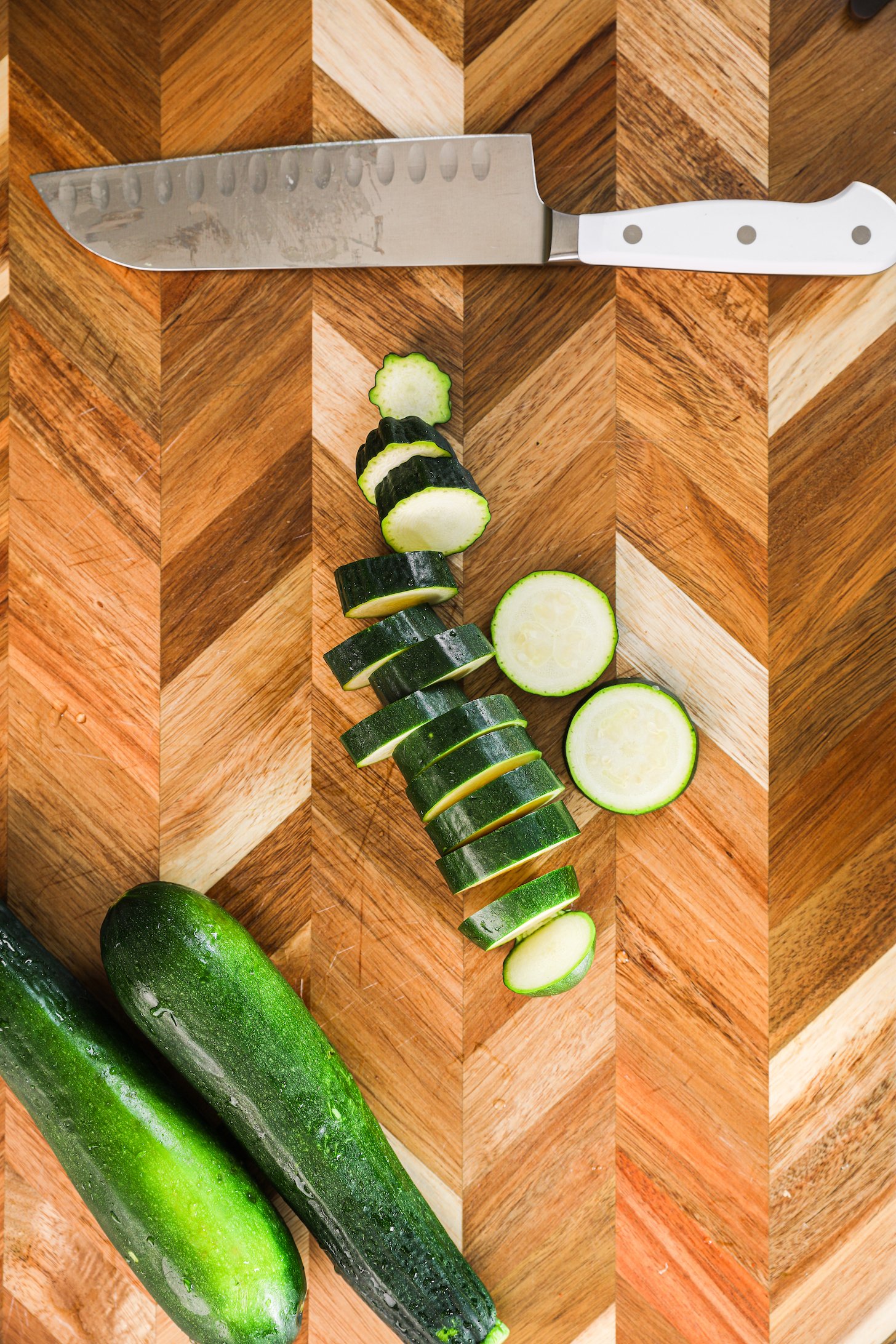 A collection of zucchini slices with a knife close by.