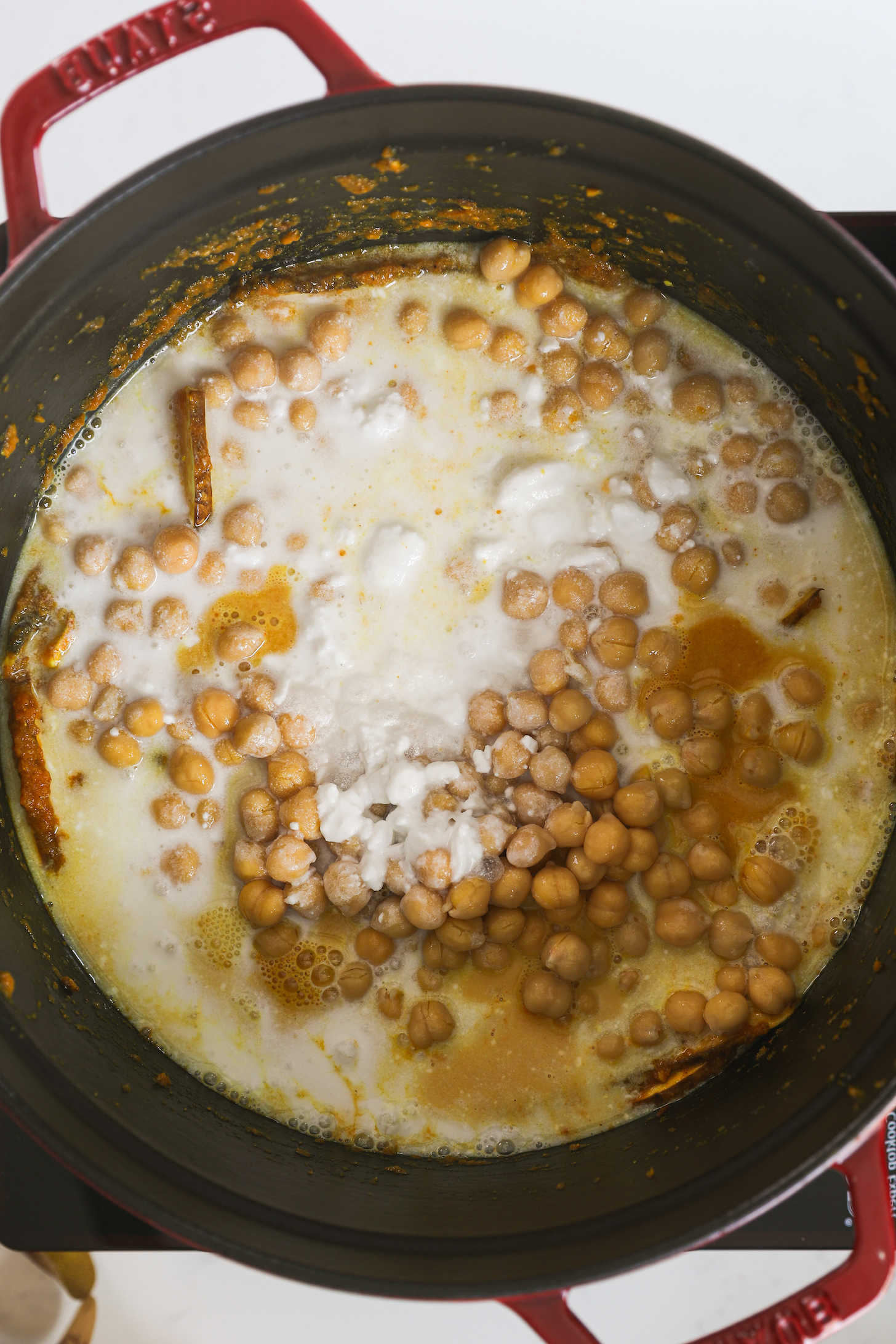 A cooking pot with chickpeas and coconut milk.