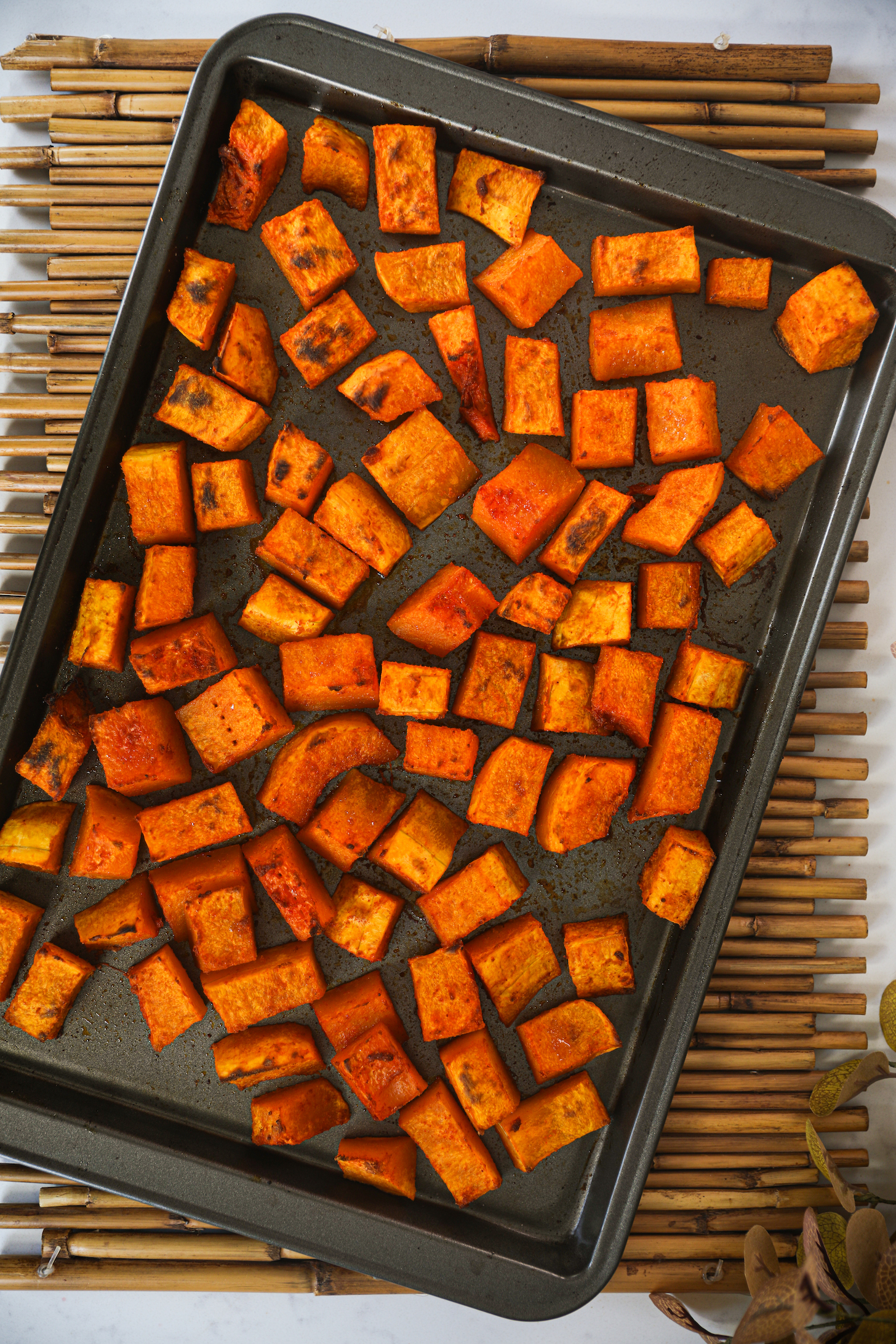 An oven tray with roasted chunks of butternut squash.