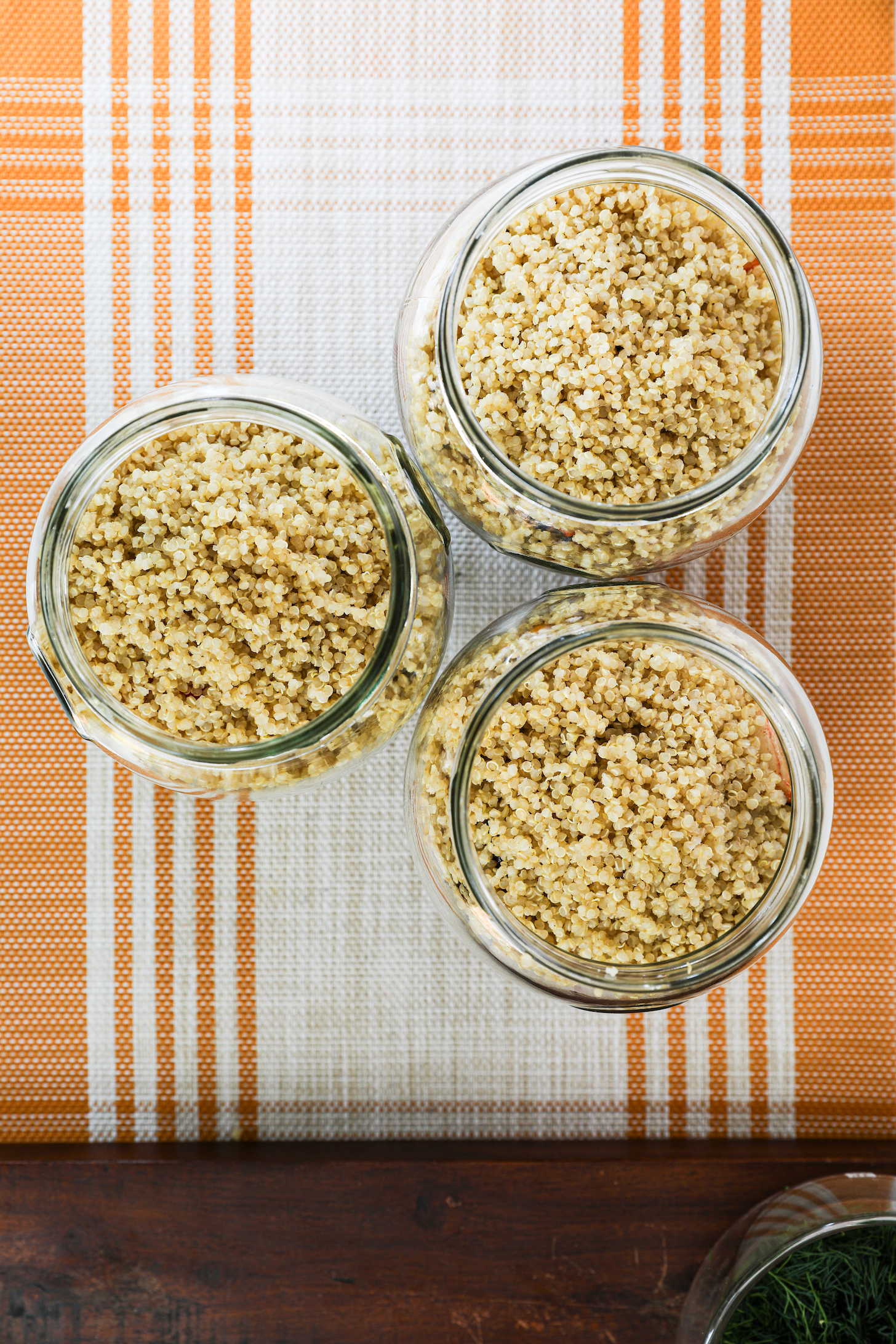 Three glass jars filled with cooked quinoa.
