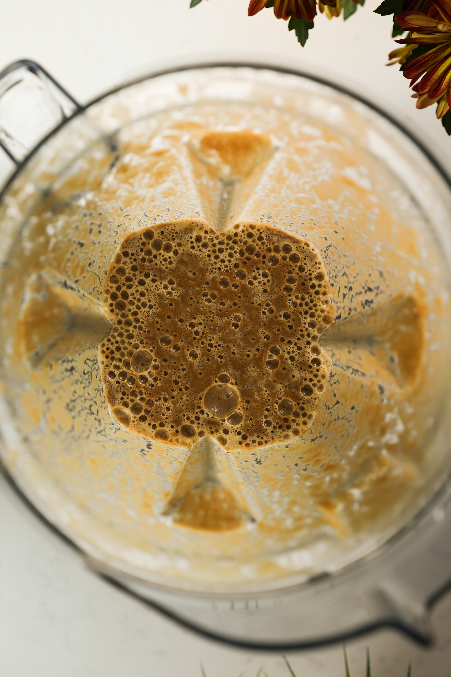 A top-down view of a blender with a frothy brown liquid after blending.