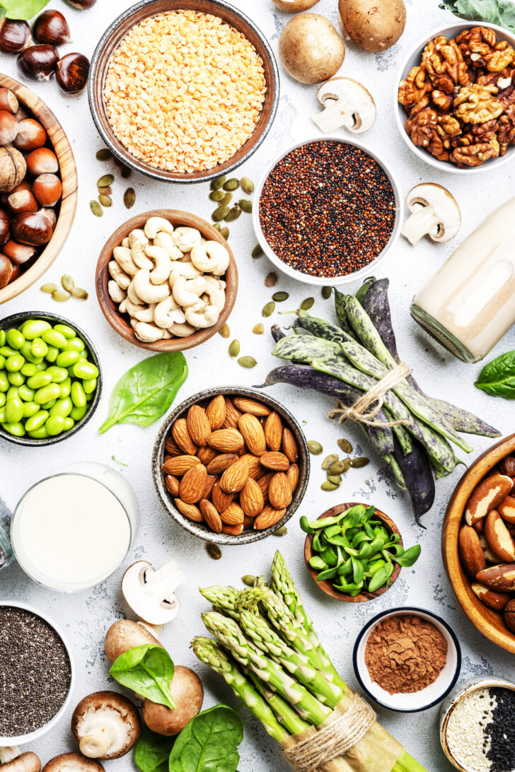 Vegan protein. Full set of plant based vegetarian food sources. Healthy eating, diet ingredients: legumes, beans, lentils, nuts, soy and almond milk, tofu, quinoa, chia, vegetables, spinach, seeds and sprouts. Top view