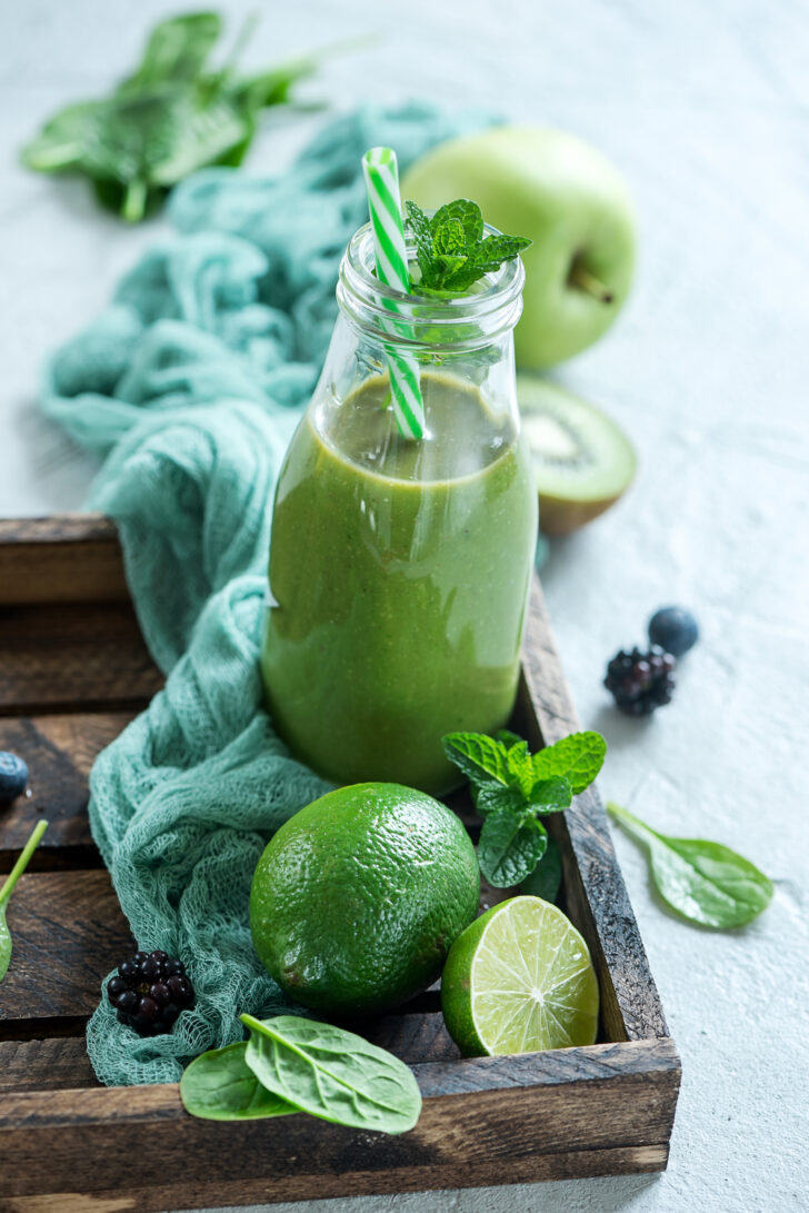 Green smoothie with spinach and lime, healthy juicy vitamin drink diet or vegan food concept, fresh vitamins