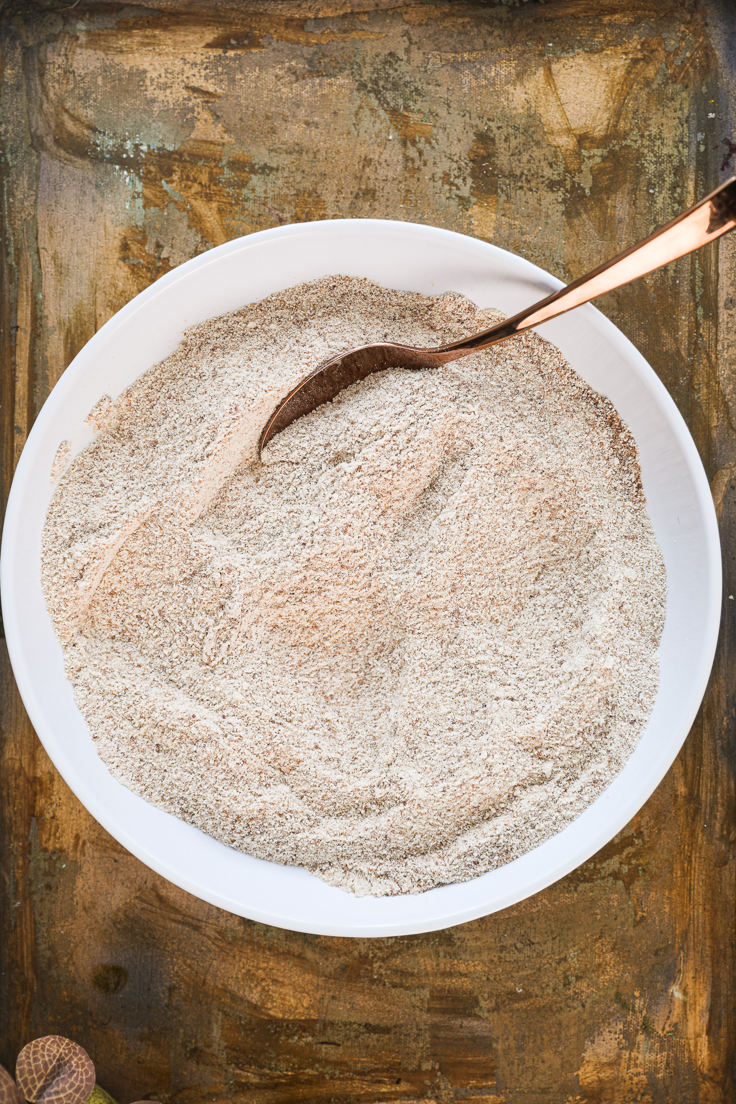 A bowl of flour with a spoon nestled inside.