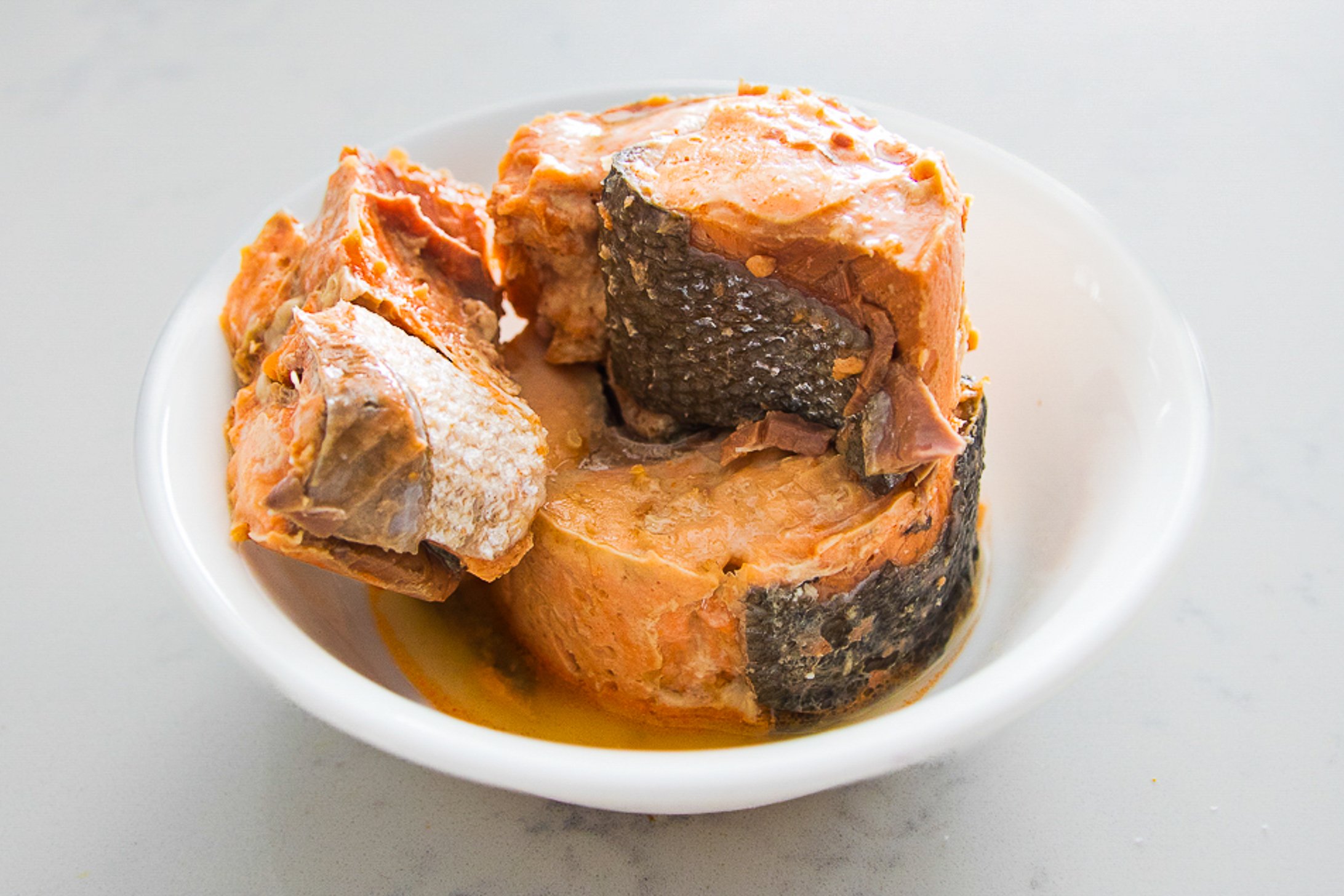 A bowl filled to the rim with canned salmon with skin.