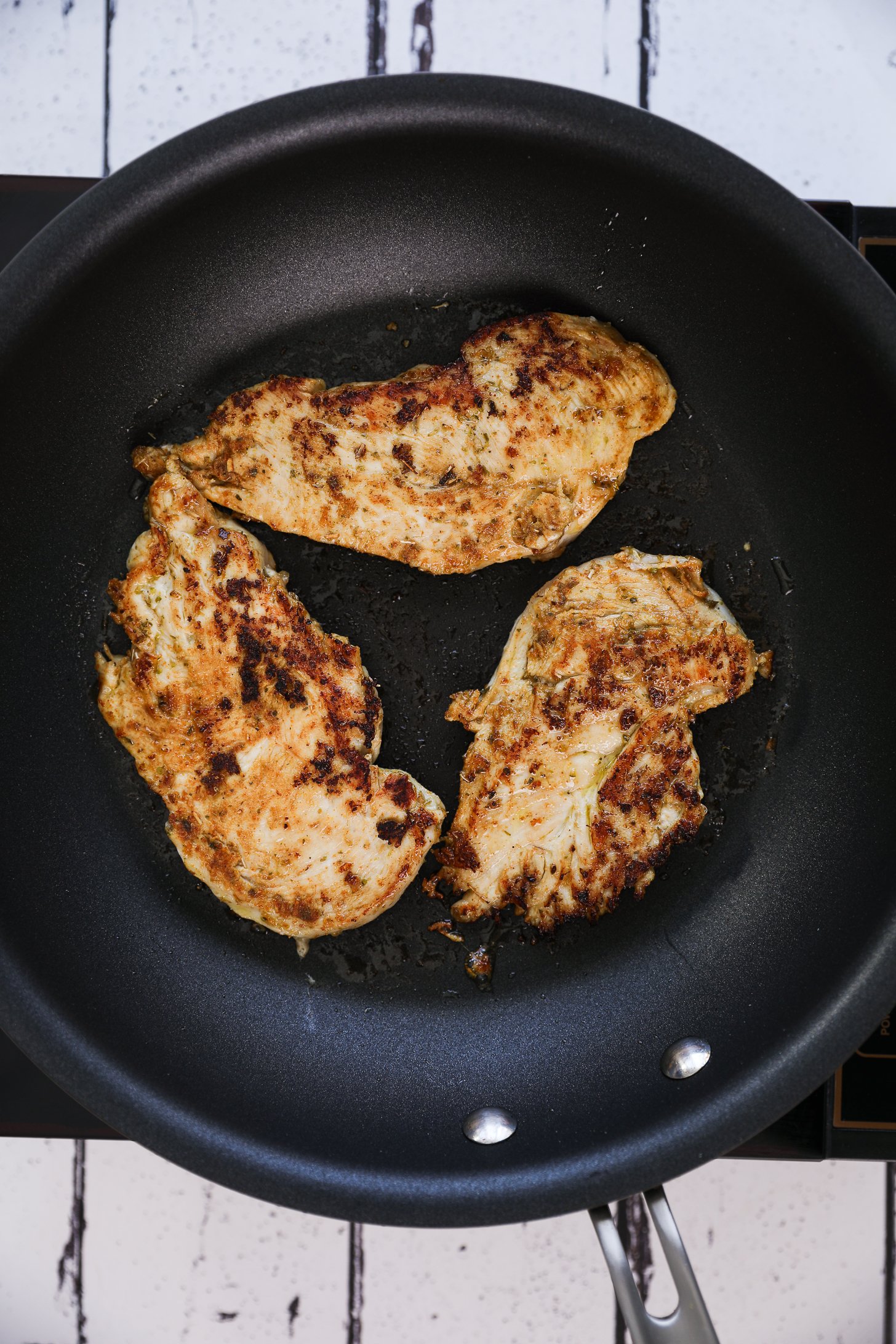 Golden fried spicy chicken cooking in a pan.