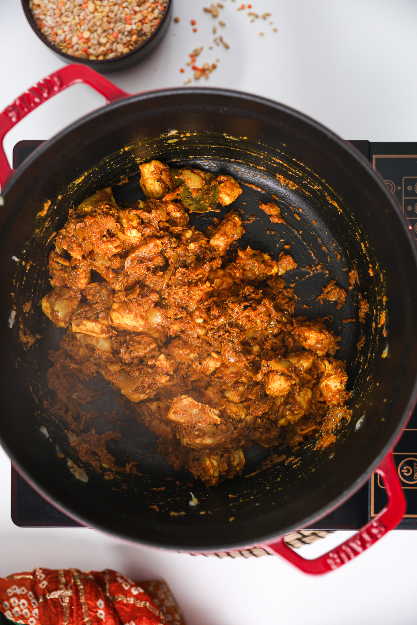 Spice-coated chicken breast chunks in a cooking pot.