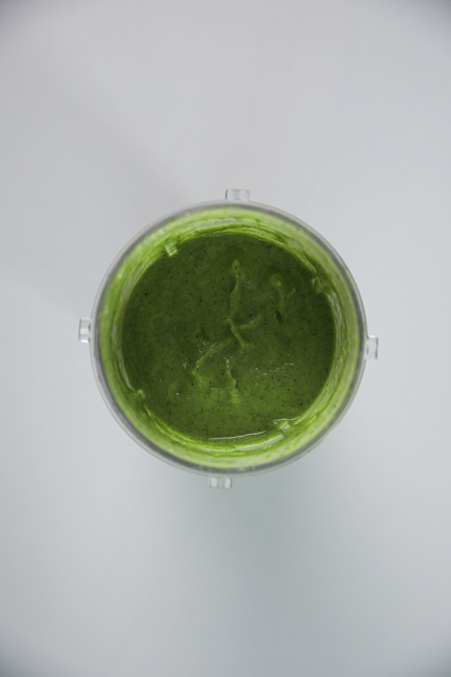 Compact blender cup containing creamy avocado cilantro lime dressing.