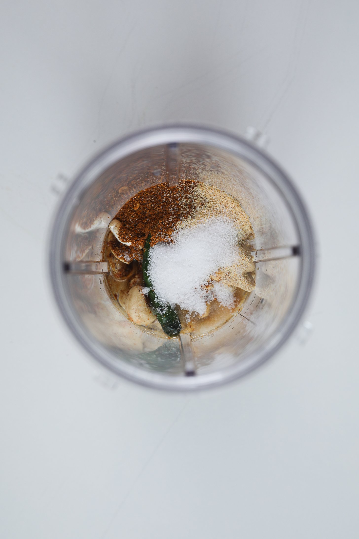یک فنجان مخلوط کن فشرده حاوی نمک، بادام هندی، ادویه جات ترشی جات و فلفل سبز.