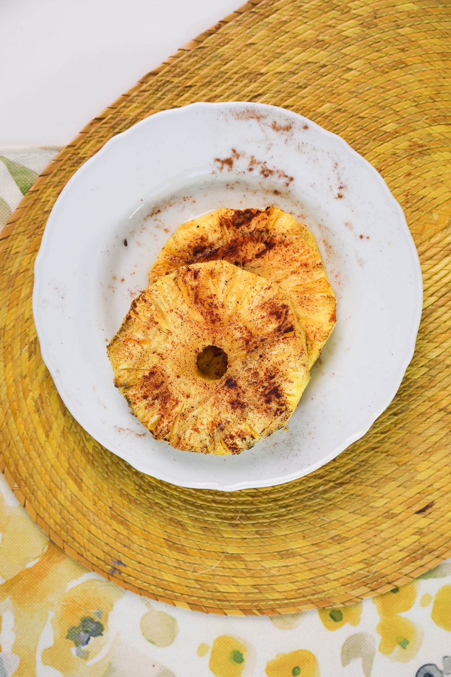 A plate of two grilled pineapple rings.