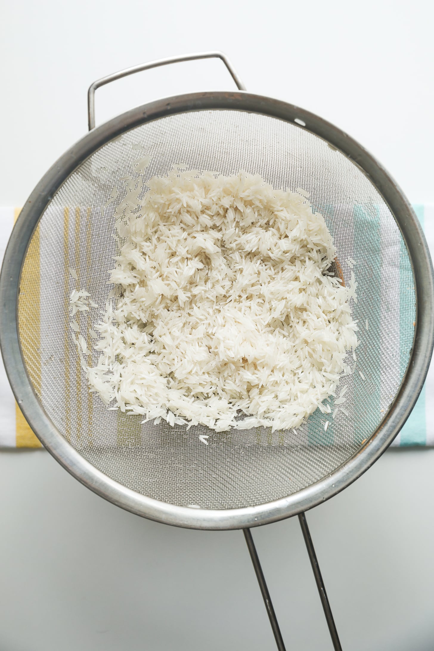 Soaked rice draining in a sieve.