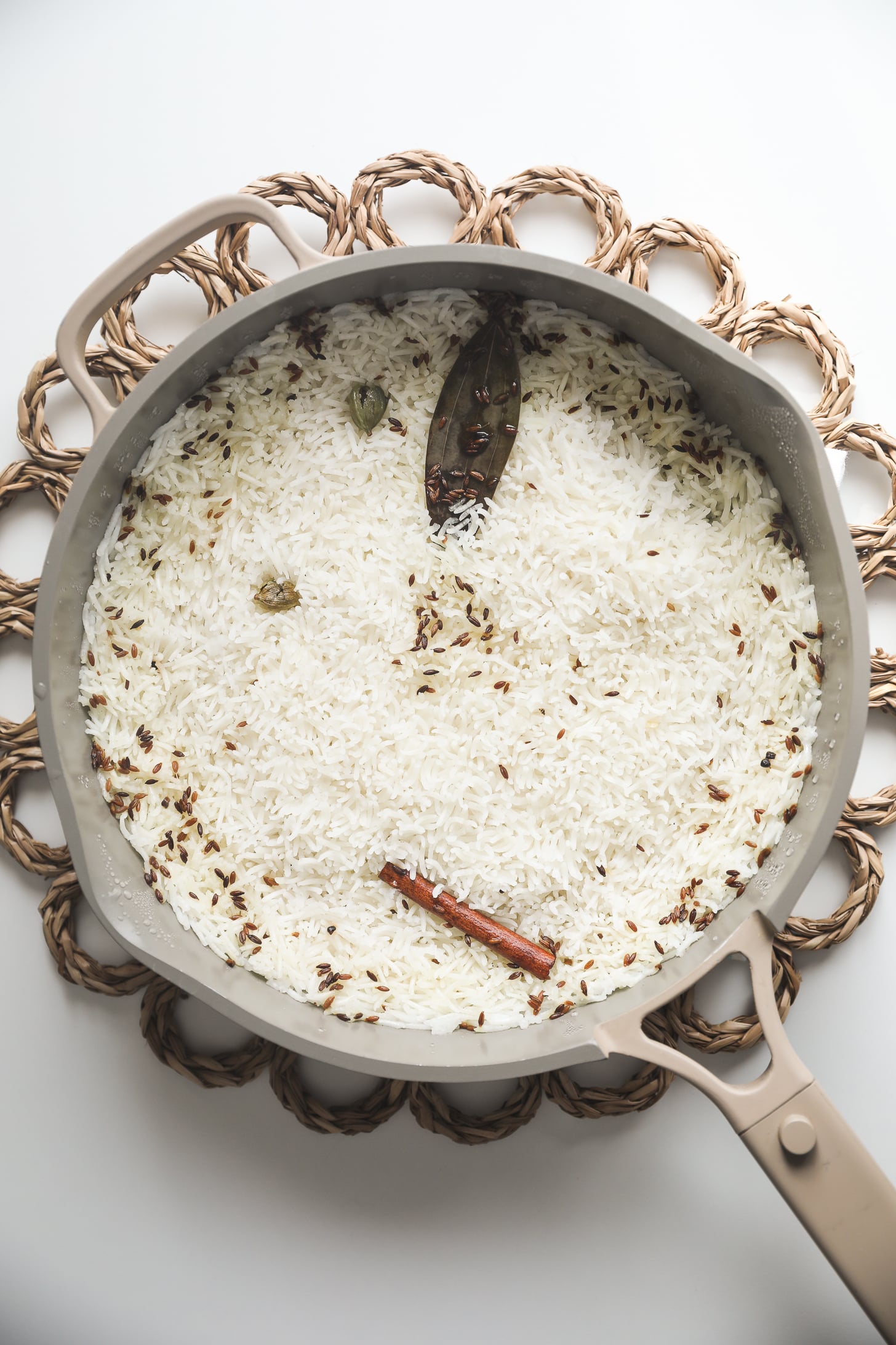 Rice and whole spices cooked in a pan.