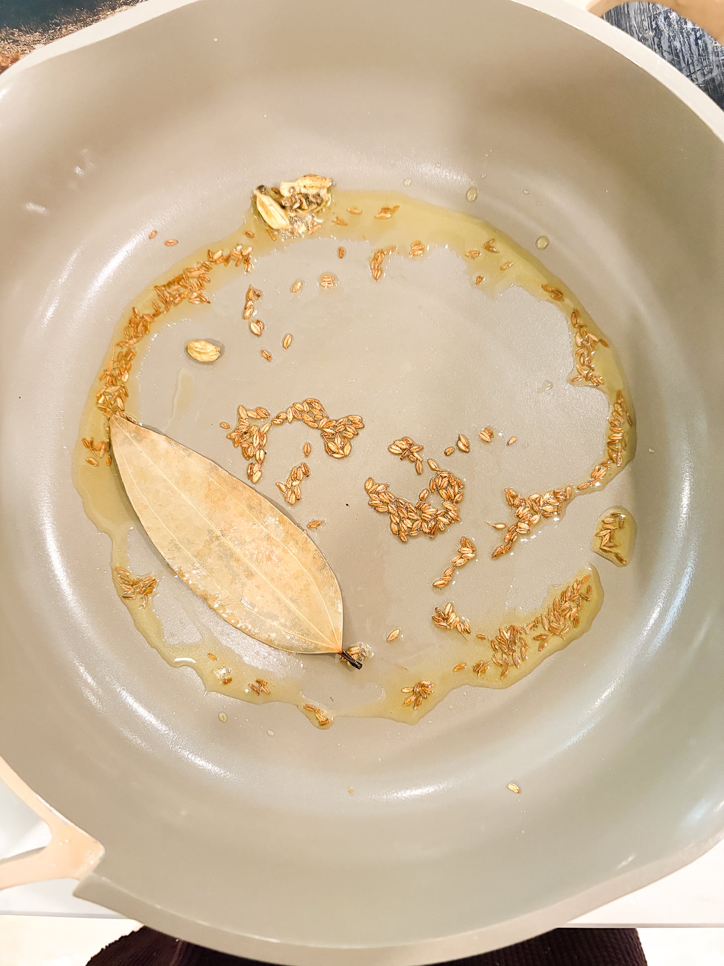 Riz au curcuma indien sur la cuisinière (si facile !) 2 Poêle à frire avec les graines de cumin, le laurier, la cardamome et l'huile.